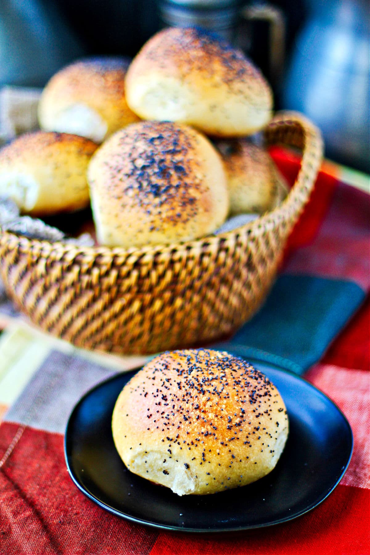 Dinner rolls in a basket with a plated roll in front.