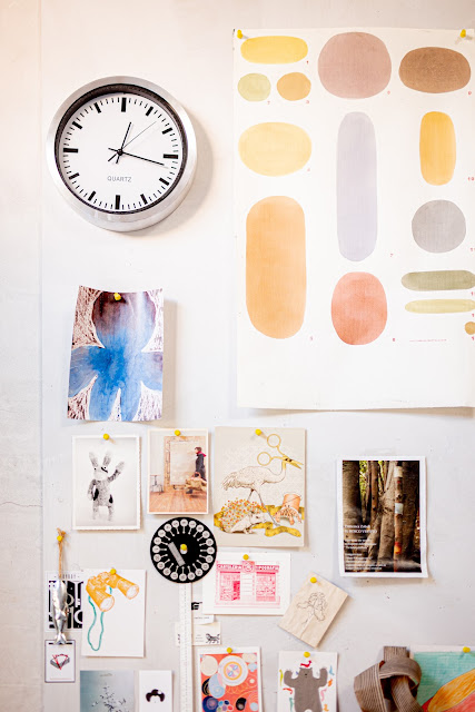 A mood board with paintings and magazine cut-outs on display.