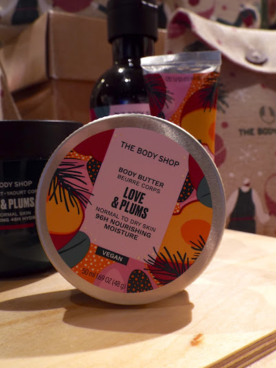 The colourful pink and purple toned packaged Love and Plums Body Butter, in recycled plastic tubs with tin lids.