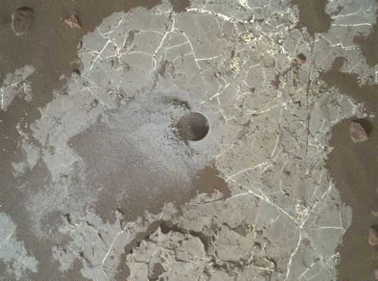 Esta imagem mostra o furo feito pelo rover Curiosity para coletar amostras na cratera Gale em Marte.