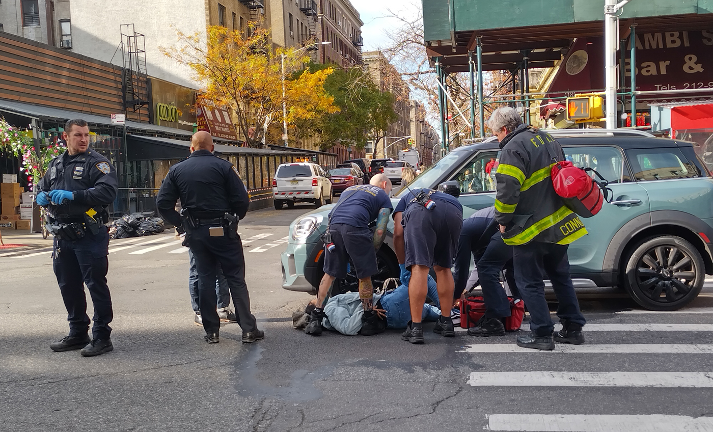 NUEVA YORK._ Una mujer no identificada recibe atención de paramédicos y policías después de colapsar en el asfalto de la avenida Broadway y calle 177 en el Alto Manhattan la mañana de este viernes 3 de diciembre 2021 por un conductor en medio del caos prevalente del tránsito vehicular en esa zona. (Foto Miguel Cruz Tejada).