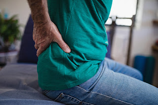 A man sitting whiles holding his waist