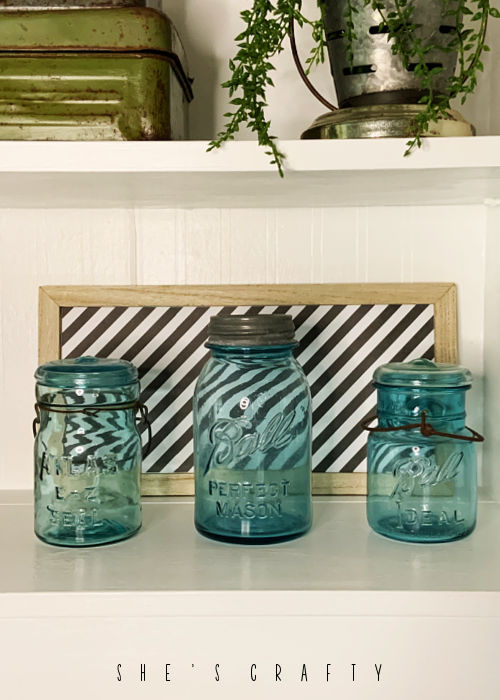 Easy Art on the back of a shelf with blue mason jars.