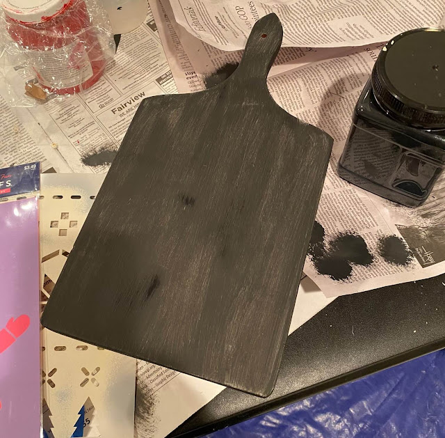 Photo of a cutting board being paint in black chalk paint.