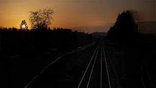 Geradewegs voran den Schienen nach. Bahnstrecke in Frauenfeld beim Einnachten.