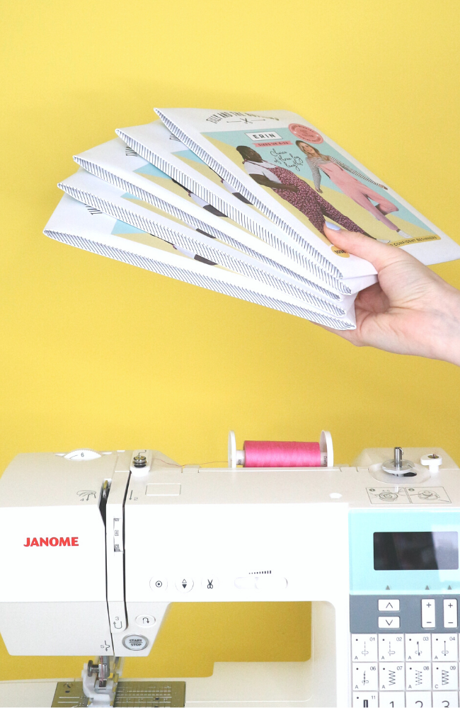 A stack of Erin sewing patterns and a sewing machine
