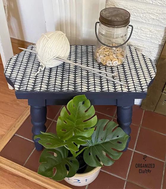 Photo of a navy chalk painted stool stenciled with a cable knit cozy sweater stencil.