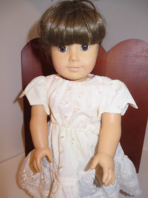 A girl doll in fancy eyelet off white Victorian dress