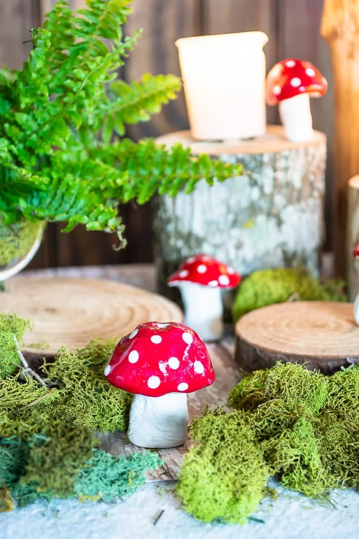 woodland vignette with red DIY mushrooms, moss, wood slices
