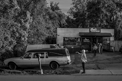 black and white photogrph of woman standing by old hearse outside of a music venue in Nashville, Tennessee