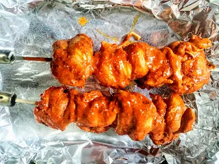 Two shewers of chicken Angara kabab on a baking tray