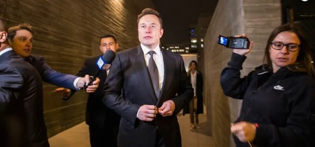 Alt: = "photo of Elon Musk fielding questions from pressmen"