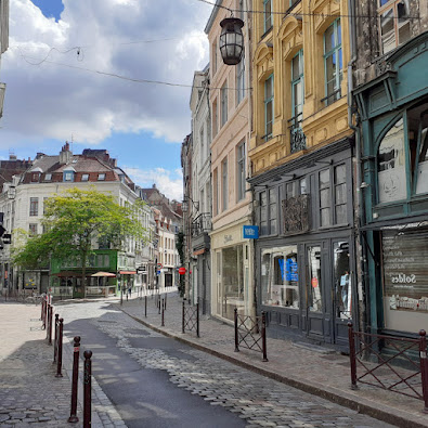 quartier de lille centre avec immeuble de rapport jaune et rue en paves