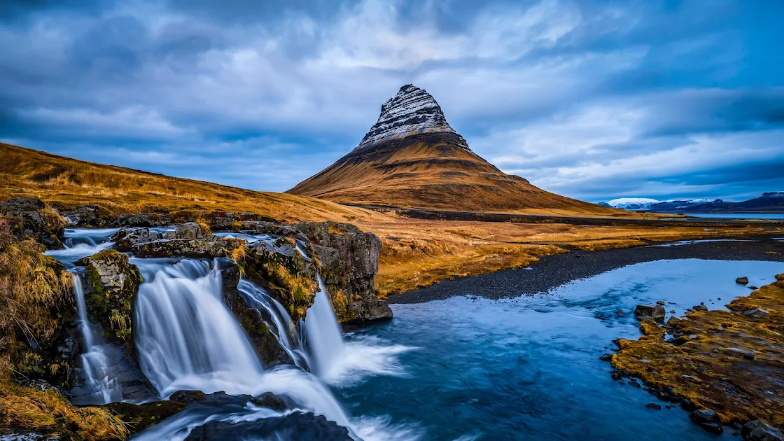 Kirkjufell mountain with its cascading waterfall set against a moody Icelandic sky in a captivating 4K wallpaper.