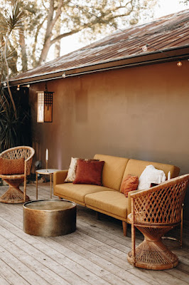 tan loveseat sitting area with two wicker chairs