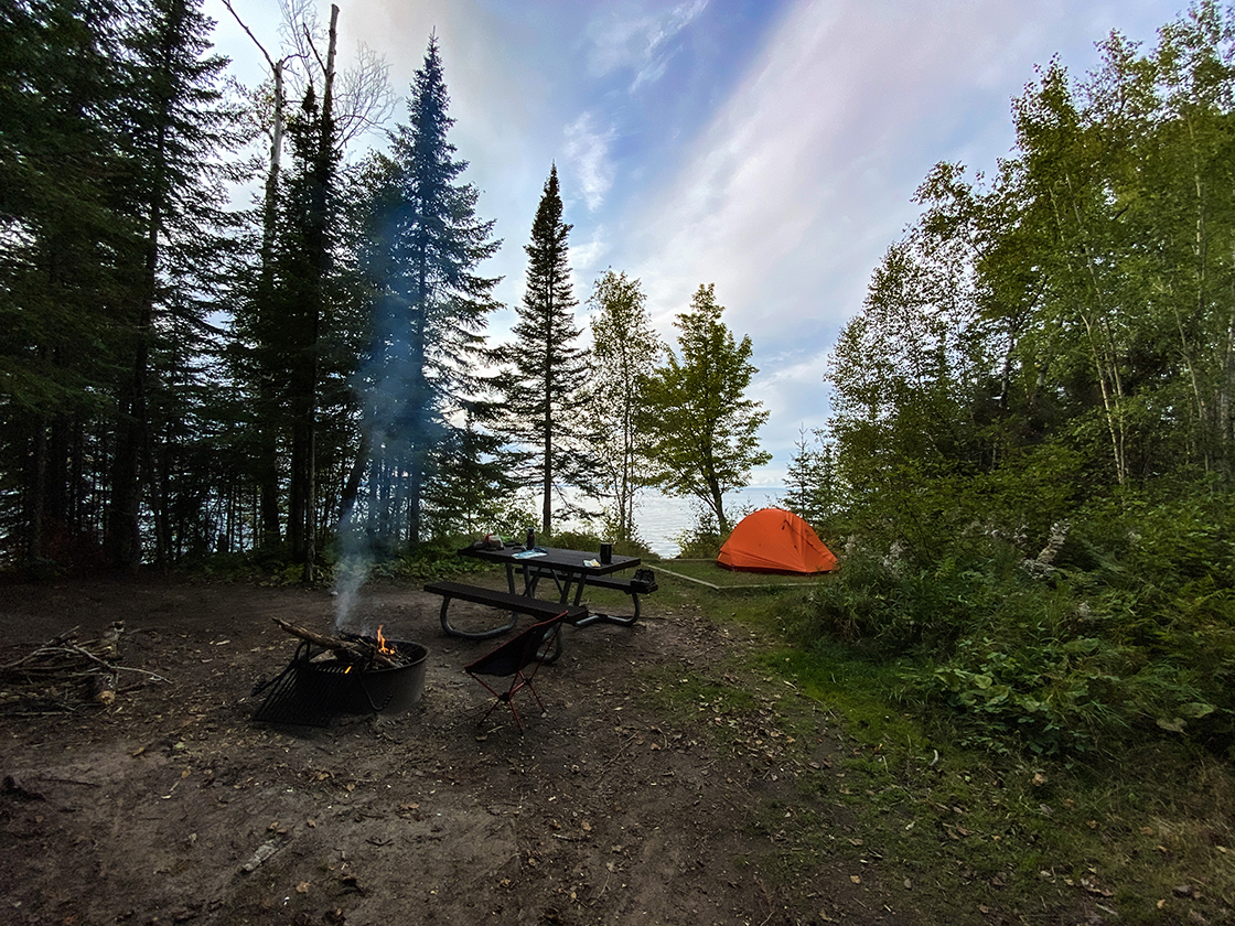 tent picnic  table and fire ring on a rise above a great lake