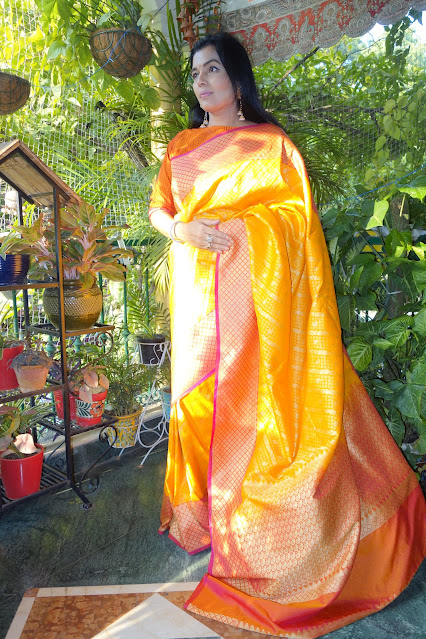 Banarasi ektara silk saree. Yellow with broad red borders. It has zari diagonal stripes as we find in Peetambari.