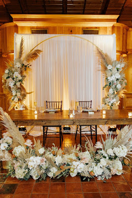 sweetheart table with flowers and arch