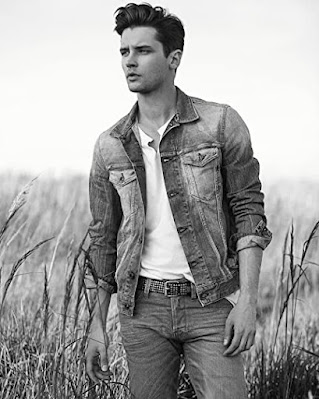 Young man in jeans and a denim jack looking into the distance