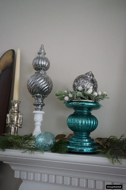Candlesticks with cedar and pine on mantel