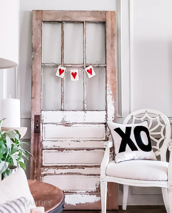 chippy vintage door with heart garland, old chair with XO pillow