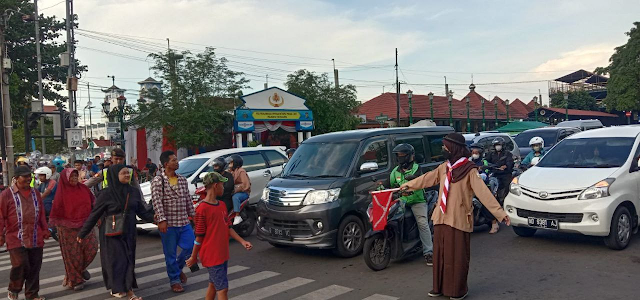 Relawan Pramuka SMA Negeri 6 Yogyakarta Membantu Mengamankan Lalu Lintas di Sekitar Jalan Abu Bakar Ali