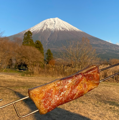 出来立てのベーコンを、富士山をバックに写す