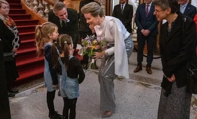 Queen Mathilde wore a silk top, blouse from Natan, and a grey silver sequin high waisted straight leg trousers from Natan