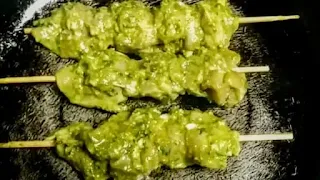 Cooking three sticks of chicken pahadi kabab on a pan or tawa