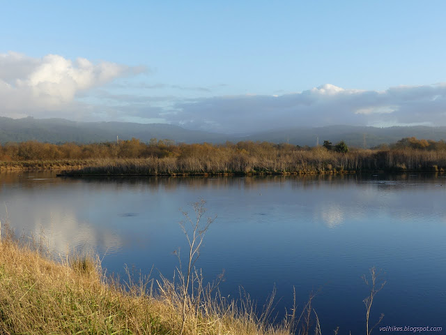 18: water with an island, blue sky storms in distant mountains