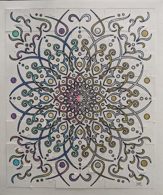 photo of final puzzle, drawn, cut, and colored in; all white background, left half colored in rainbow colors and right half colored with gold and silver