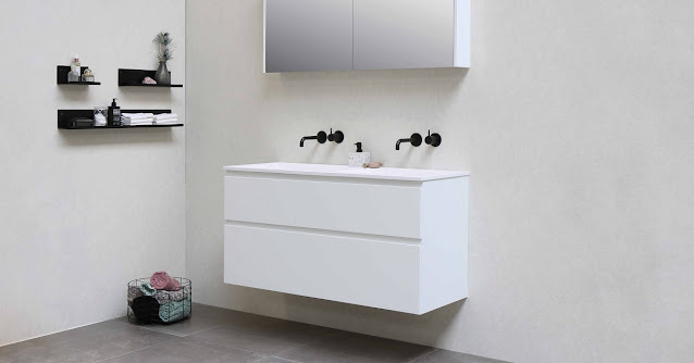 Dark fixtures at a white wall-mounted vanity in the bathroom.