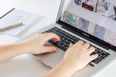 Hands typing on laptop keyboard