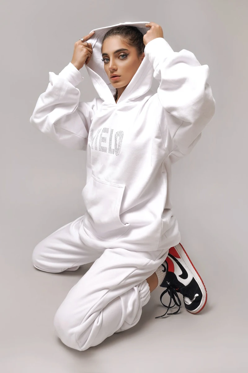 woman in a beautiful white hoodie and joggers posing in the srudio