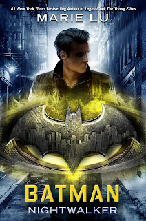 A white teenager with dark hair, his face is in shadows. In front of him is a metal Batman logo backlit by a golden light.