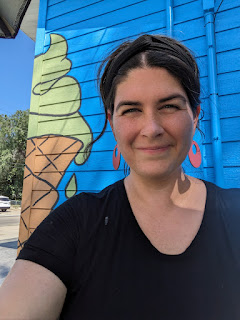 a woman smiles in front of a green painted ice cream cone on the wall of Jason's in Sioux City