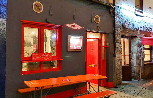 Ember Firehouse chicken restaurant: brown/grey restaurant walls, with firehouse-red door and windowframes.   Set up by the team from Handsome Burgers in Dominick Street - but with a classier menu.