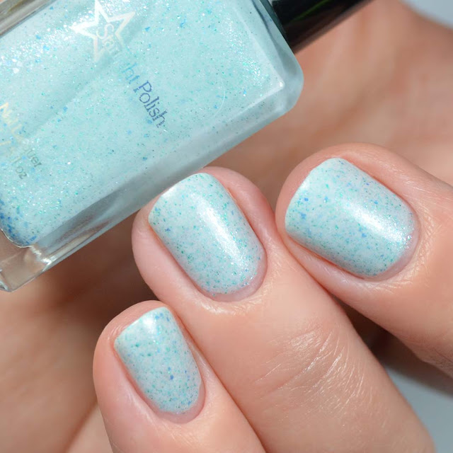 white crelly nail polish with blue flakies and glitter swatch