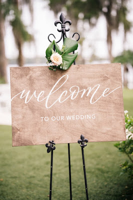 wooden welcome sign on black easel