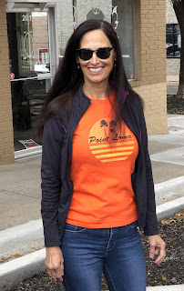 woman with long hair, sunglasses, jeans, orange t-shirt 