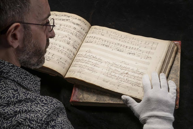Museum of London librarian Lluis Tembleque Teres with one of Emma Hamilton's songbooks (Photo John Chase/Museum of London)