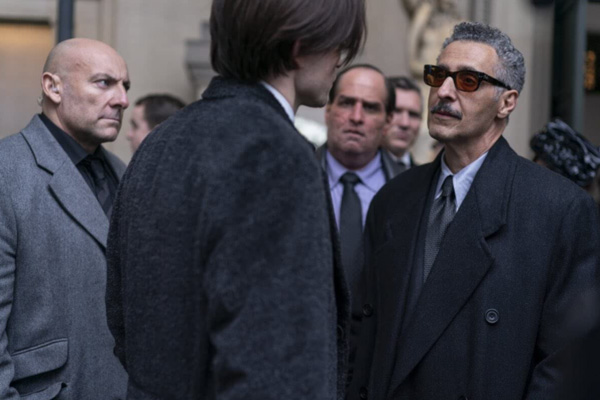 As Penguin (Colin Farrell) looks on, Bruce Wayne confers with Carmine Falcone (John Turturro) in THE BATMAN.