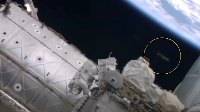 Silver metallic UFO caught spying on the Astronauts during a spacewalk.