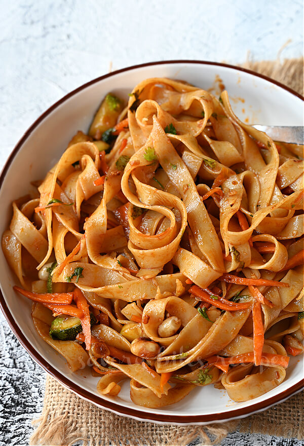 a white plate with spicy thai noodles