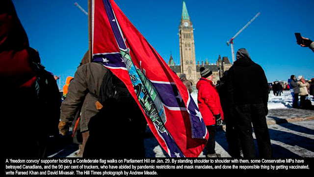 A ‘freedom convoy’ supporter holding a Confederate flag walks on Parliament Hill on Jan. 29. By standing shoulder to shoulder with them, some Conservative MPs have betrayed Canadians, and the 90 per cent of truckers, who have abided by pandemic restrictions and mask mandates, and done the responsible thing by getting vaccinated, write Fareed Khan and David Mivasair. The Hill Times photograph by Andrew Meade.