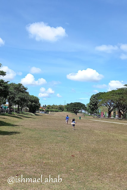 Kids running on green grass of Nuvali Park in Santa Rosa, Laguna