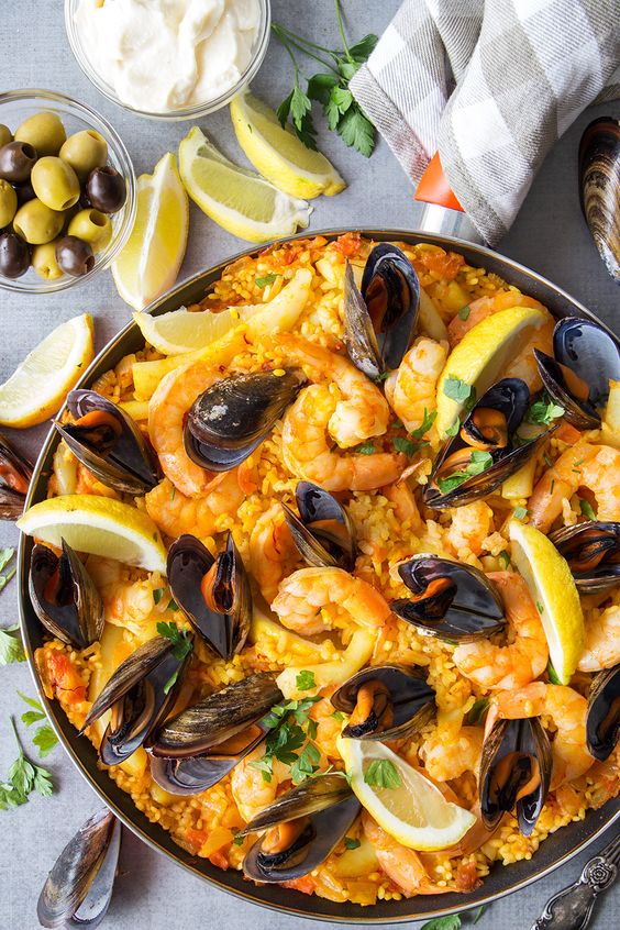 This Spanish Seafood Paella features a saffron infused rice cooked together with veggies and topped with shrimp, squid, and mussels. A perfect seafood dish!