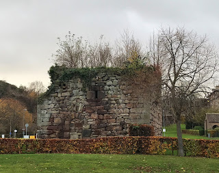 A photo showing a squat, square stone building, Craiglockhart Castle, that is in ruins.  There is a doorway blocked off with stone and vegetation grows out of the top of the building. Photo by Kevin Nosferatu for the Skulferatu Project.