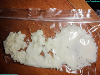 about 2 teaspoons of milk kefir grains in a transparent ziploc bag on a wooden table