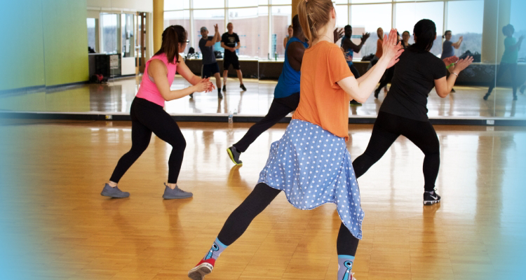 Diverse group of people learning dance moves in a class.